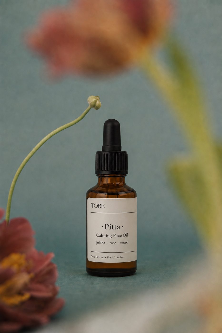 Pitta calming face oil among flowers