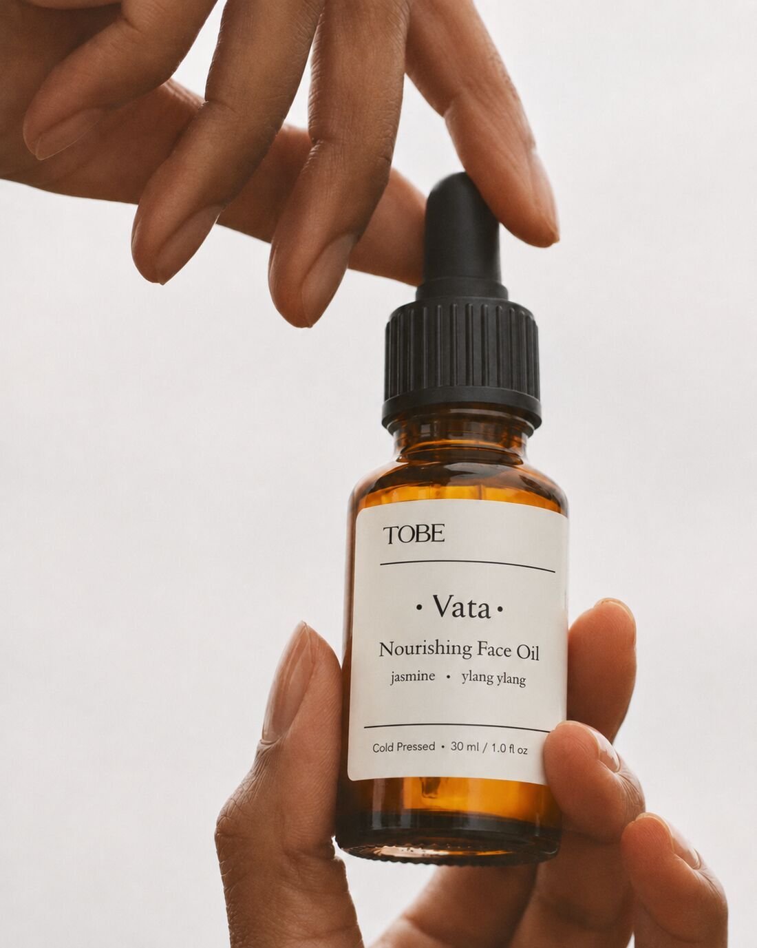Hand holding the TOBE Vata face oil